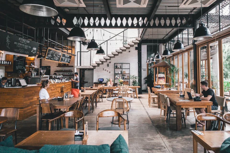 Ahşap masalı, yüksek tavanlı kafe iç mekânı